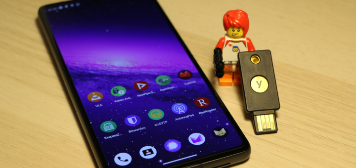 Smartphone with open source apps and a Lego figure holding a Yubikey
